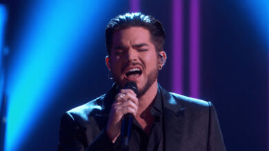 Edited illustration of Adam Lambert passionately singing Believe under blue concert lighting.